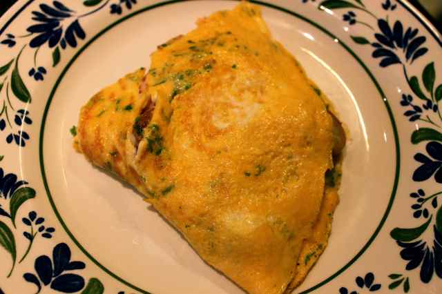 Parsley, ham and potato omelette on plate